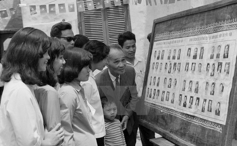 Cử tri khu phố Nhà Chung, khu Hoàn Kiếm, Hà Nội xem danh sách ứng cử viên trước ngày bầu Quốc hội thống nhất.