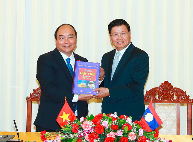 Thủ tướng Chính phủ Nguyễn Xuân Phúc (trái) trao tặng Thủ tướng Thongloun Sisoulith bộ Từ điển Việt - Lào, Lào - Việt.Ảnh: TTXVN