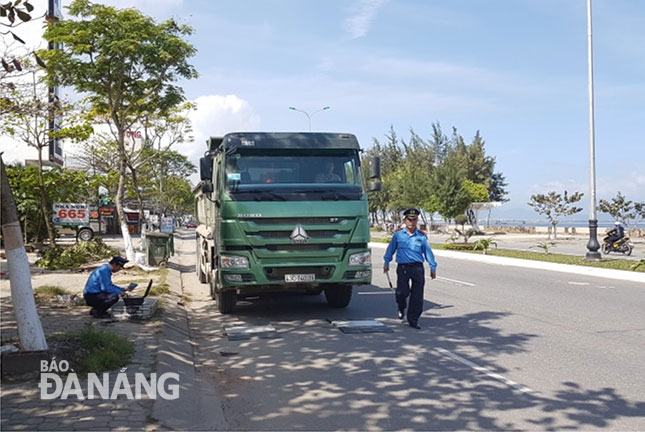 Lực lượng chức năng kiểm tra một trường hợp xe ben chở vật liệu xây dựng lưu thông trên đường Nguyễn Tất Thành (địa bàn quận Thanh Khê).