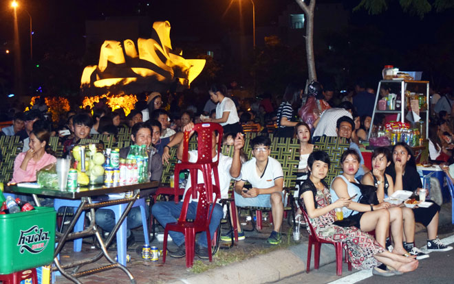 Người dân chờ thưởng thức màn khai cuộc pháo hoa tại bờ sông Hàn đường Như Nguyệt. Theo người dân, giá đồ ăn thức uống vỉa hè không đắt so với bình thường 