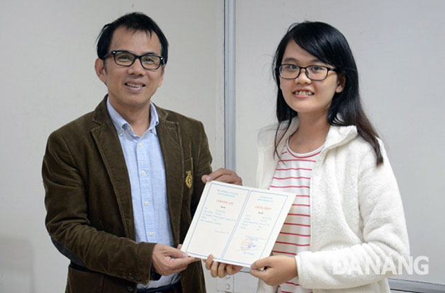 Sinh viên Trần Mỹ Dung (phải) nhận Giấy chứng nhận hoàn thành khóa học tiếng Nhật do Đại học Đà Nẵng tổ chức. 