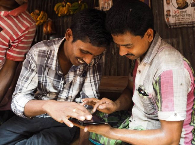 Hai người đàn ông chơi trò Angry Birds trên điện thoại ở Bangladesh.