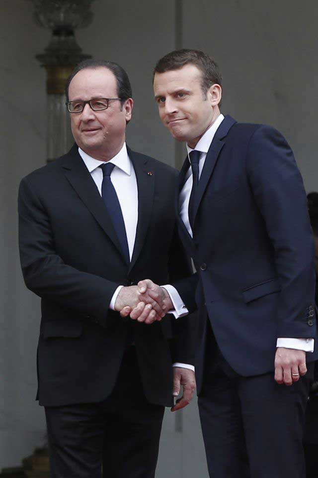 Tổng thống vừa mãn nhiệm Francois Hollande (trái) chào đón tân Tổng thống Emmanuel Macron trong lễ nhậm chức. 			          Ảnh: AP