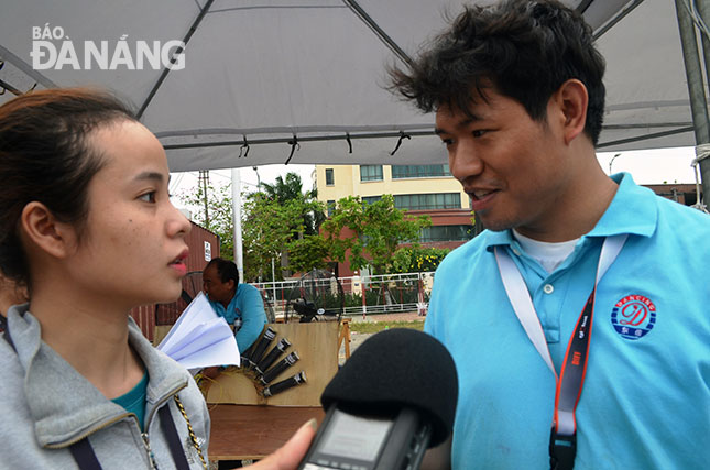 Các phiên dịch viên đã góp phần không nhỏ trong thành công của các đội tham dự Lễ hội pháo hoa quốc tế Đà Nẵng 2017.  Trong ảnh: Nhật Hiền (trái) đang hỗ trợ các phóng viên phỏng vấn đội trưởng đội Trung Quốc.
