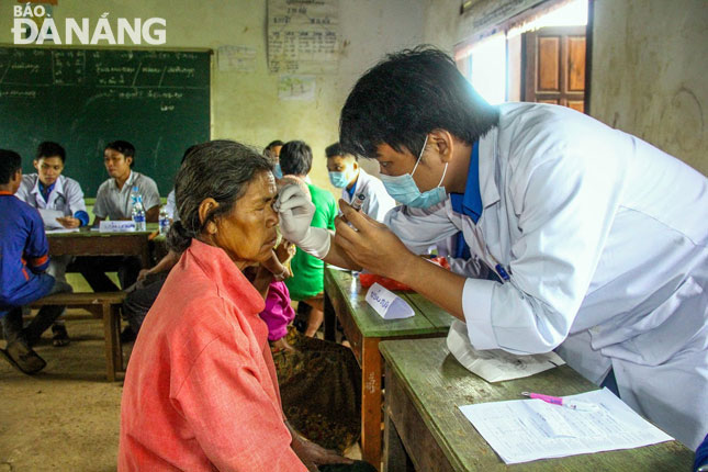 Các y bác sĩ trong đoàn đến từ nhiều bệnh viện tại Đà Nẵng với nhiều chuyên khoa khác nhau như: mắt, tai-mũi-họng, sản-nhi…Trong ảnh: Bác sĩ Trương Công Gia Thịnh, Bệnh viện Mắt (bên phải) khám mắt cho một bệnh nhân.