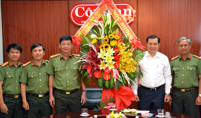 Chủ tịch UBND thành phố Huỳnh Đức Thơ (thứ hai từ phải sang)  tặng hoa chúc mừng lãnh đạo Báo Công an Đà Nẵng.