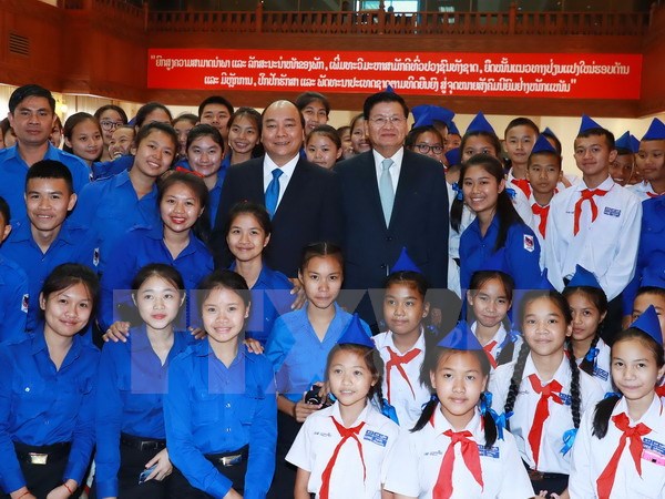 Thủ tướng Nguyễn Xuân Phúc và Thủ tướng Lào Thongloun Sisoulith với các em học sinh tại lễ phát động Năm Đoàn kết hữu nghị Việt Nam-Lào 2017. (Ảnh: Thống Nhất/TTXVN)