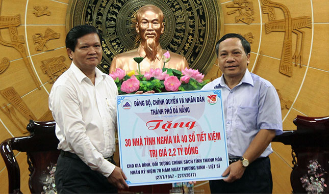 Phó Chủ tịch HĐND thành phố Nguyễn Nho Trung (trái) trao tặng 30 nhà tình nghĩa và 40 sổ tiết kiệm (tổng trị giá 2,2 tỷ đồng) cho các gia đình chính sách tỉnh Thanh Hóa. Ảnh: ĐẮC MẠNH