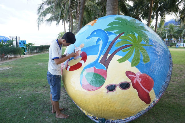 Thành Tuấn đang hoàn thiện bức tranh thúng tại khu vực Công viên Biển Đông.