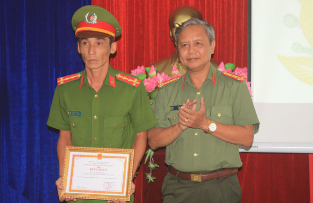 Đại tá Lê Thanh Hải, Phó Giám đốc Công an thành phố Đà Nẵng, trao giấy khen cho Đại úy Võ Văn Tùng.