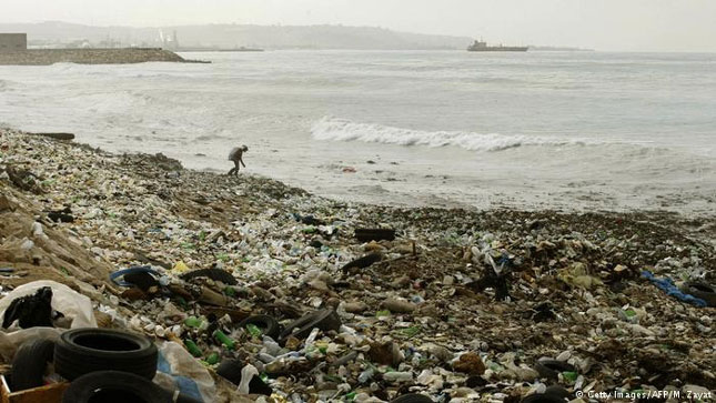 Người đàn ông Lebanon đi nhặt rác trên bờ biển.