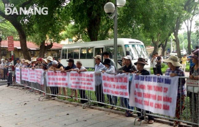 Mỗi lần ra Hà Nội, các hộ dân ở khu vực Cồn Dầu thường xuyên căng băng rôn, biểu ngữ ở khu vực trước tòa nhà Quốc hội để “kêu oan”.  													Ảnh: A.N