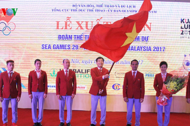 Trưởng đoàn Trần Đức Phấn phất cao cờ Tổ quốc, thể hiện quyết tâm của các thành viên Đoàn Thể thao Việt Nam tại SEA Games 29. 				          Ảnh: VOV