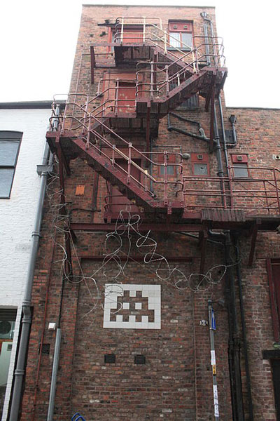 Một bức tranh khảm của  Invader trên tường ở  Manchester, Anh (2004).