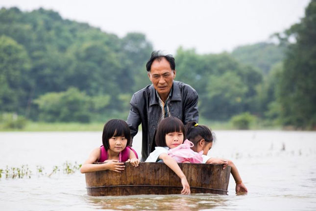 Người đàn ông lấy bồn tắm đưa con đi học ở vùng bị ngập lụt tỉnh Giang Tây (Trung Quốc).