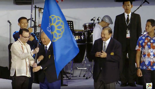 Đại diện Philippines (bìa trái) nhận cờ SEA Games, được Chủ tịch Ủy ban Olympic Malaysia Tan Sri Tunku Imran Tuanku Jaafar (thứ hai, từ phải sang) trao tại lễ bế mạc SEA Games 29.