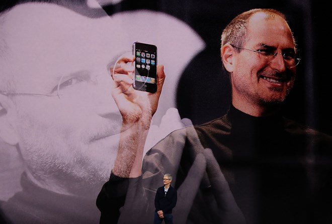 Hình ảnh Steve Job cùng chiếc iPhone đầu tiên trên sân khấu hội trường Steve Jobs Theater. (Nguồn: Getty)