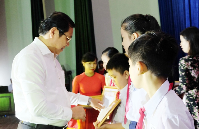 Municipal People’s Committee Chairman Huynh Duc Tho presenting Certificates of Merit and the reward to the honourees