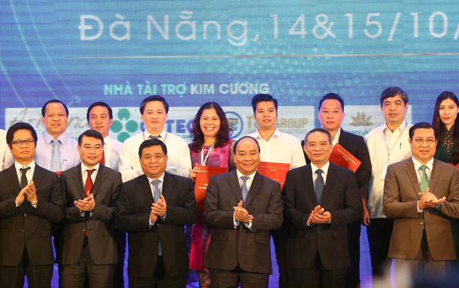 Prime Minister Phuc (1st row, 3rd right), Secretary Nghia (1st row, 2nd right), Chairman Tho (1st row, 1st right), and other delegates at the forum