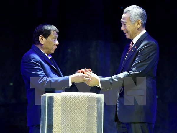 Philippine President Rodrigo Duterte (L) hands over the gavel to Singaporean Prime Minister Lee Hsien Loong during a transfer of Asean Chairmanship at the closing ceremonies of the 31st Asean Summit and Related Summits in Manila on November 14 (Photo: Xinhua/VNA)