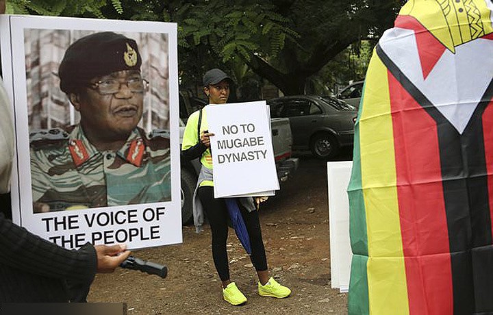 Bên trái là chân dung tư lệnh quân đội Chiwenga, với dòng chữ tiếng Anh “Tiếng nói của nhân dân”. Bên phải là tấm biển “Nói không với Mugabe”. Ảnh: AP.