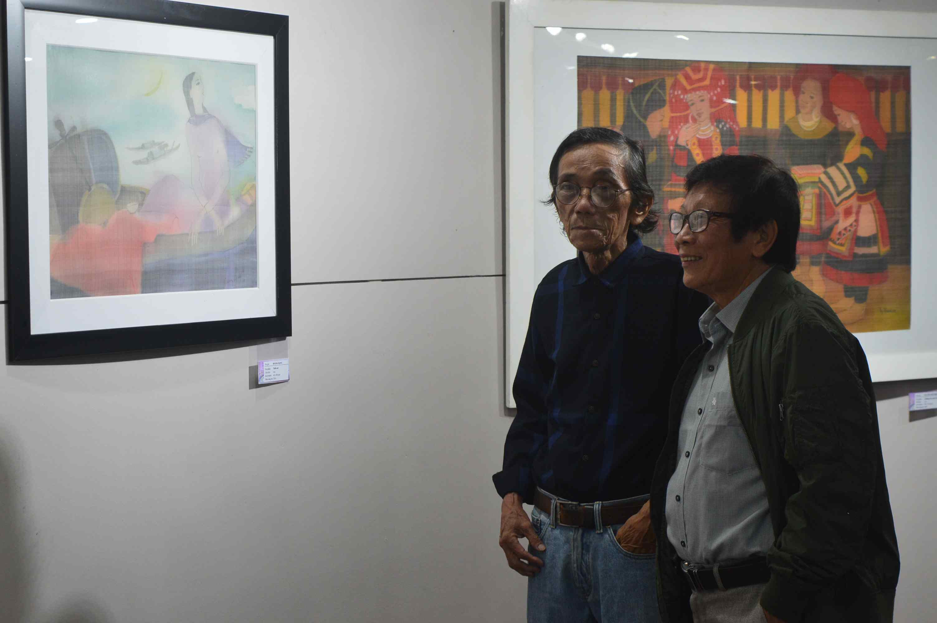 Visitors viewing the displayed paintings at the exhibition