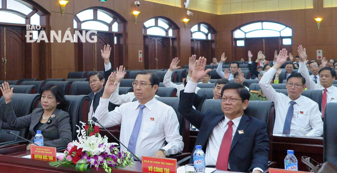 Các đại biểu giơ tay biểu quyết thông qua nghị quyết bãi nhiệm chức danh Chủ tịch HĐND thành phố, đại biểu HĐND thành phố khóa IX, nhiệm kỳ 2016-2021 đối với ông Nguyễn Xuân Anh