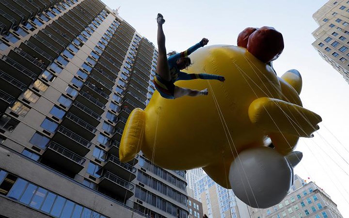   Một hoạt náo viên tung người lên không, gần chạm tới quả bóng khổng hình Pikachu trên Đại lội 6.