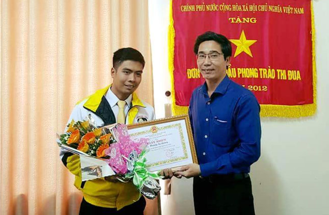 Deputy Director Cuong (right) presenting the Certificate of Merit to taxi driver Luong