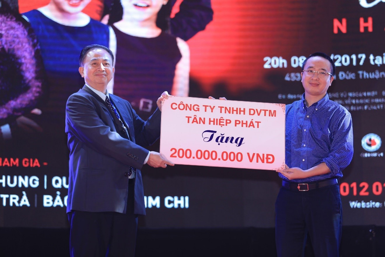 Ông Nguyễn Phan Huy Khôi, Giám đốc Đối ngoại Tập đoàn Tân Hiệp Phát trao bảng tượng trưng số tiền 200 triệu cho đại diện BTC.  
