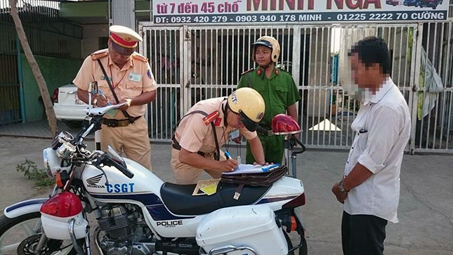 Cảnh sát giao thông lập biên bản xử lý vi phạm hành chính đối với người vi phạm giao thông.