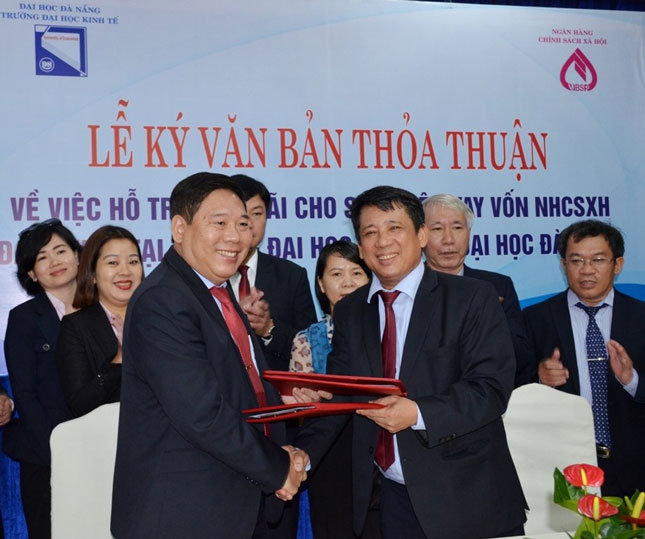 Đại diện Trường ĐH Kinh tế (ĐH Đà Nẵng, bên trái) và Ngân hàng Chính sách xã hội Việt Nam trao thỏa thuận ký kết hỗ trợ trả lãi vay cho sinh viên nghèo. (Ảnh do Trường ĐH Kinh tế cung cấp)