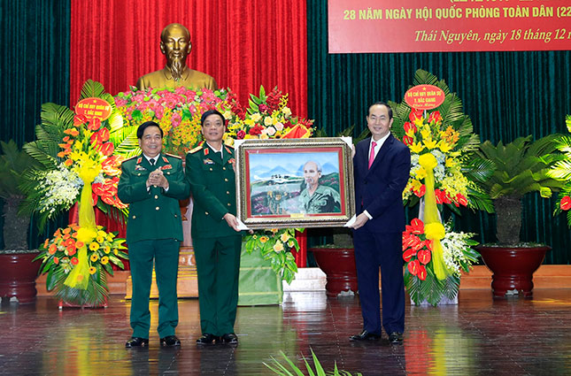 Chủ tịch nước Trần Đại Quang tặng bức tranh “Bác đang cùng chúng cháu hành quân” cho Bộ Tư lệnh Quân khu 1.   				            Ảnh: TTXVN
