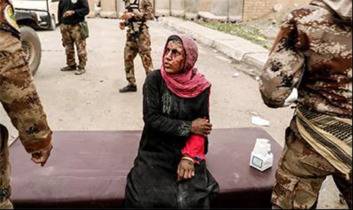  Một phụ nữ bị thương được điều trị trong khi lực lượng Iraq chiến đấu với các chiến binh Hồi giáo, ở phía tây Mosul, Iraq.