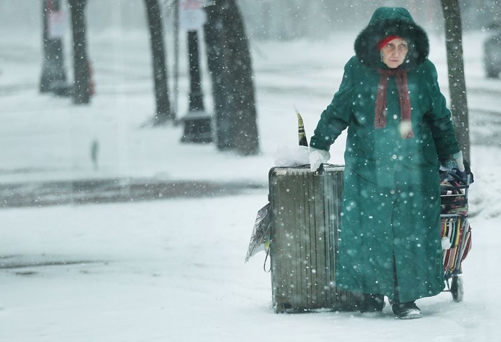 Người phụ nữ kéo lê đám hành lý đi trong mưa tuyết tại Boston. Ảnh: Getty Images