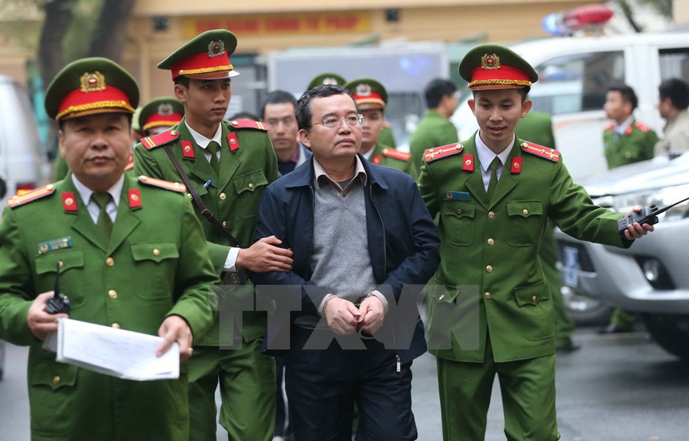 Cảnh sát dẫn giải các bị cáo Nguyễn Quốc Khánh. (Ảnh: Doãn Tấn/TTXVN)