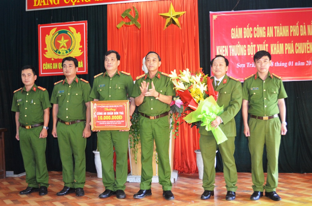 Đại tá Trần Mưu trao 10 triệu đồng của Chủ tịch UBND thành phố cho Ban chuyên án. Ảnh: NGỌC PHÚ
