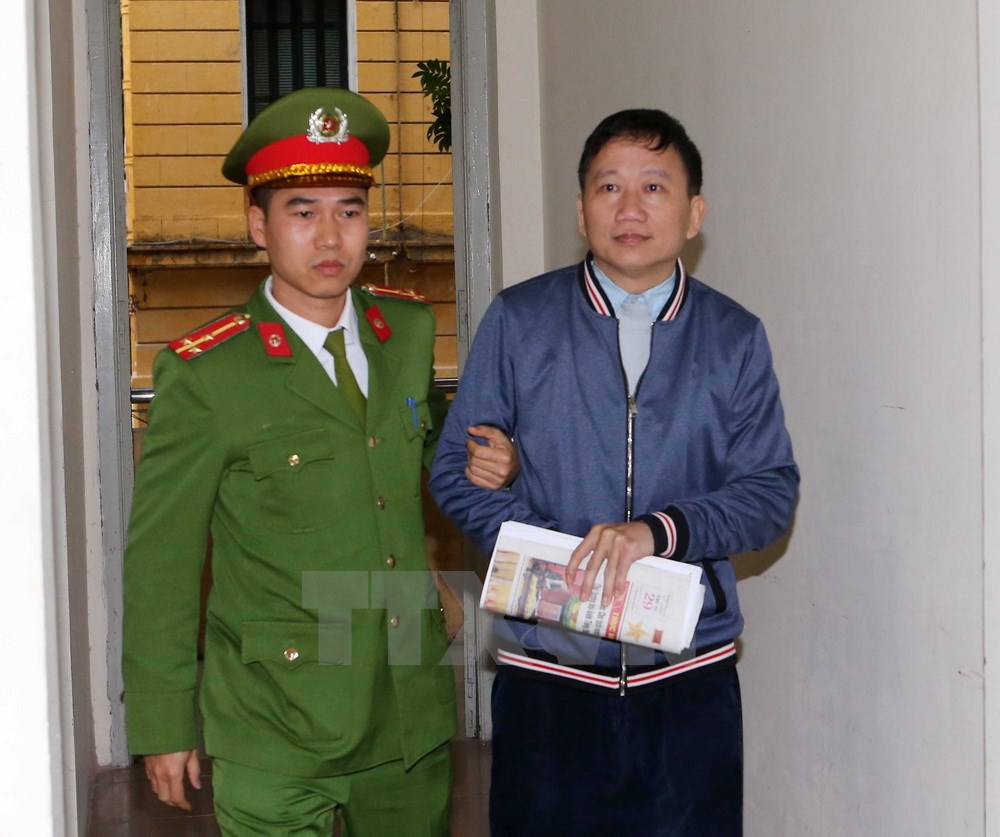 Cảnh sát dẫn giải bị cáo Trịnh Xuân Thanh vào phòng xét xử. (Ảnh: Doãn Tấn/TTXVN)