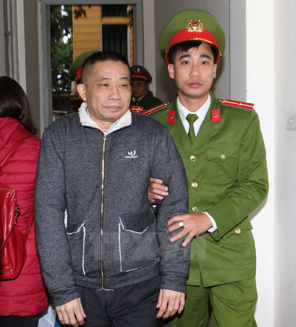 Cảnh sát dẫn giải bị cáo Ninh Văn Quỳnh (sinh năm 1958, nguyên Kế toán trưởng kiêm Trưởng Ban Tài chính Kế toán và Kiểm toán PVN) vào phòng xét xử. (Ảnh: Doãn Tấn/TTXVN)