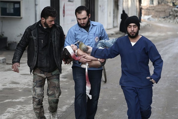 Các tình nguyện viên và nhân viên y tế đưa một em bé bị thương đến nơi an toàn. Ảnh: AFP/Getty.