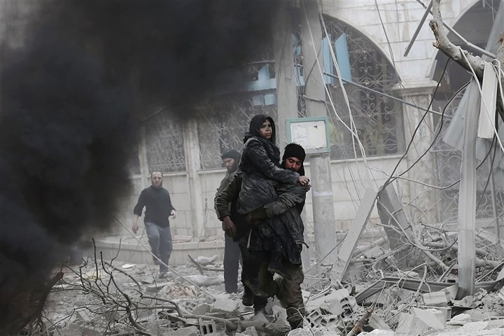 Người đàn ông bế một phụ nữ ra khỏi đống đổ nát ở Hamouriyeh hôm 6/1. Ảnh: AFP/Getty.
