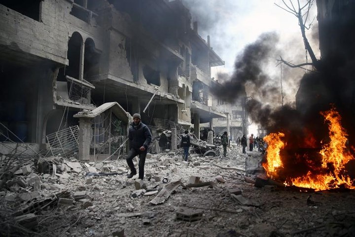 Lửa cháy ngùn ngụt gần các đống đổ nát ở Hamoria, Đông Ghouta hôm 6/1. Ảnh: Reuters.
