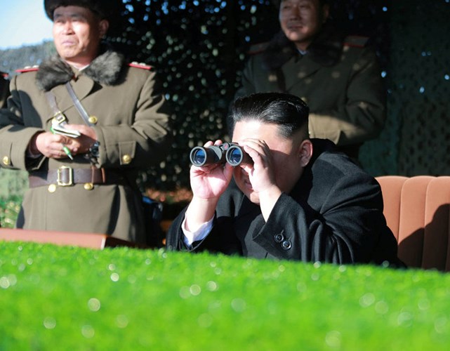 Nhà lãnh đạo Triều Tiên sử dụng ống nhòm để theo dõi một cuộc tập trận. Ảnh: Reuters.