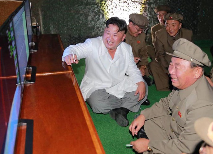 Các quan chức quân đội và ông Kim Jong-un theo dõi một vụ phóng tên lửa đạn đạo từ tàu ngầm qua màn hình. Ảnh: Reuters.