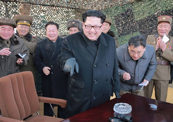 Nhà lãnh đạo Kim Jong-un tươi cười trước khi chứng kiến một vụ thử tên lửa. Ảnh: AFP/Getty.