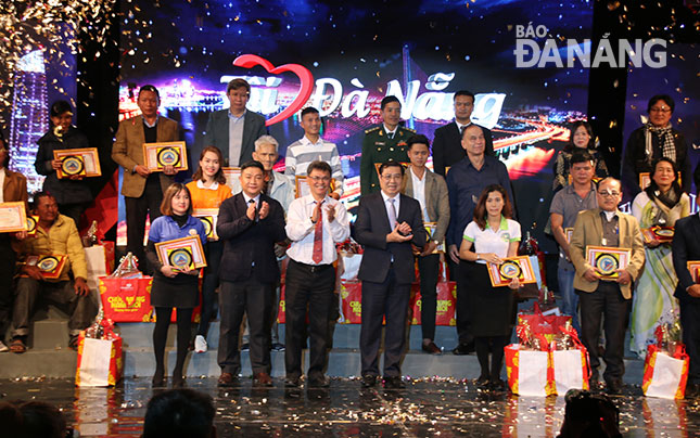 Chủ tịch UBND thành phố Huỳnh Đức Thơ trao biểu trưng thành phố Đà Nẵng cho 35 cá nhân, tập thể được tôn vinh trong chương trình “Tôi yêu Đà Nẵng”. Ảnh: KHA MIÊN