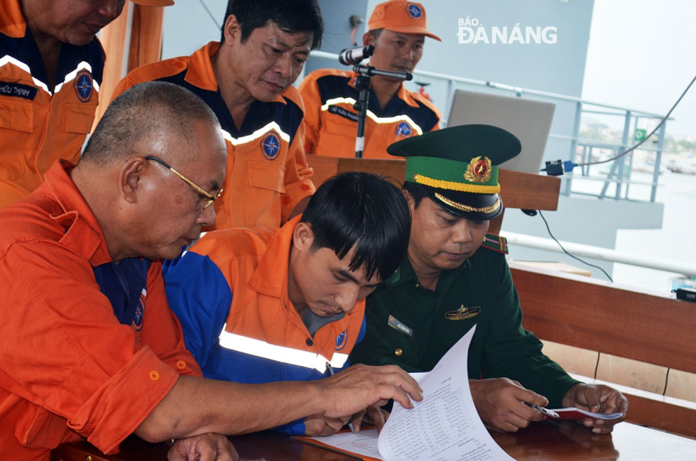 Thuyền trưởng tàu SAR 412 Phan Xuân Sơn ký biên bản bàn giao người và phương tiện cho Bộ đội Biên phòng. 