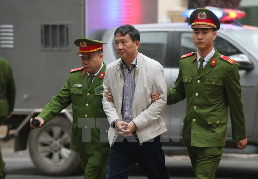 Cảnh sát dẫn giải bị cáo Trịnh Xuân Thanh, nguyên Chủ tịch Hội đồng quản trị, Tổng Giám đốc PVC tới tòa. (Ảnh: Doãn Tấn/TTXVN)