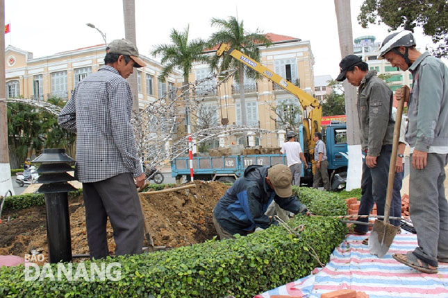 Workers from the Da Nang Green Trees-Park Company busy installing floral decorations along section of Bach Dang  