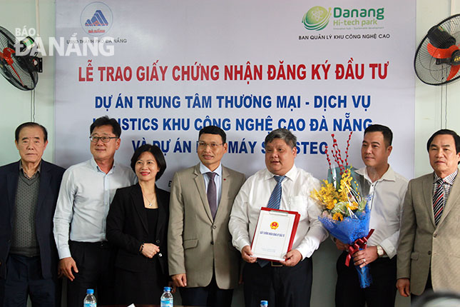 Phó Chủ tịch UBND thành phố Hồ Kỳ Minh (thứ 4, phải sang) trao giấy chứng nhận đăng ký đầu tư cho lãnh đạo Công ty CP logistics công nghệ cao Đông Nam Á. 